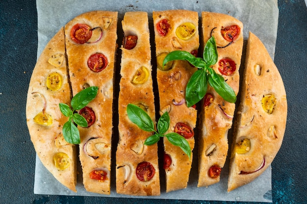 Zdjęcie domowa włoska focaccia widok z góry focaccia z pomidorami i czosnkiem jedzenie w tle