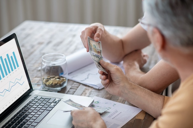 Domowe Biuro. Dwóch Mężczyzn Siedzących Przy Stole I Pracujących Na Laptopie