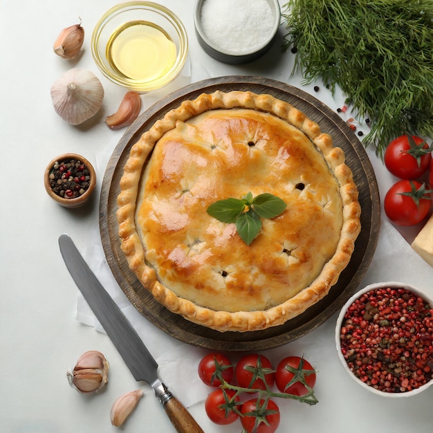Domowe ciasto jabłkowe z świeżymi jabłkami na białym kuchennym stole.