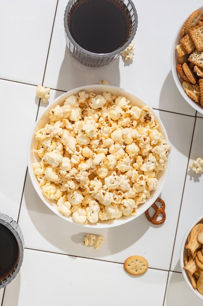 Domowe gadżety fast food miska z krakersami popcornowymi i ciasteczkami na białym stole