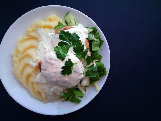 Zdjęcie domowe jedzenie puree ziemniaczane z kotletem rybnym i sosem śmietanowym