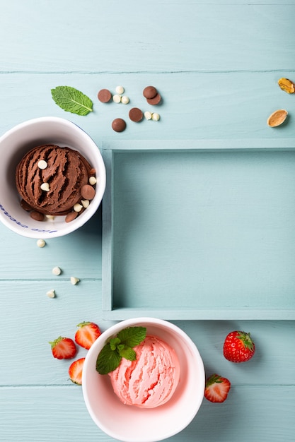 Domowe lody czekoladowo-truskawkowe na jasnoniebieskiej powierzchni drewnianej. Koncepcja zdrowej żywności lato z miejsca na kopię