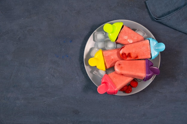 Domowe lody truskawkowe na ciemnym kamiennym stole mrożony sok owocowy w stylu vintage widok z góry