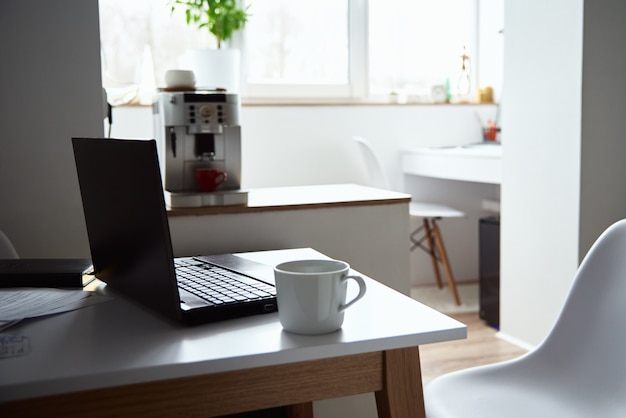 Domowe miejsce pracy freelancera. Laptop na stole we wnętrzu biura. Praca online i praca zdalna.