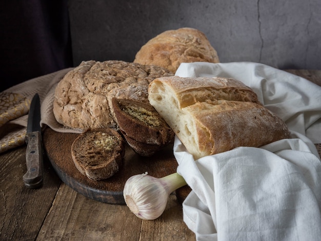 Domowe pieczywo Świeże pieczywo czosnkowe na beżowej serwetce i drewnianym stole