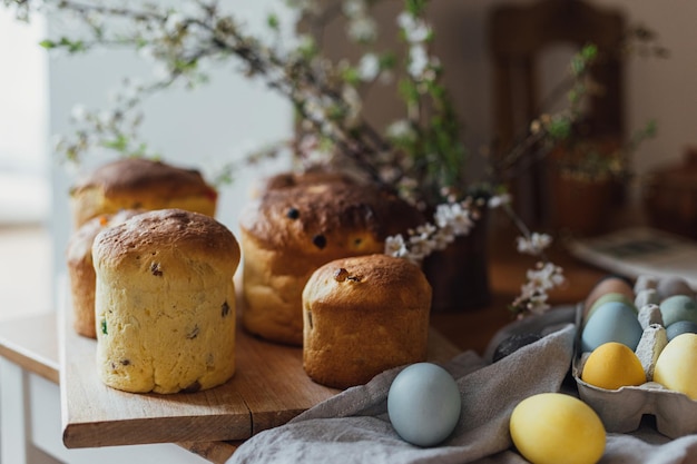 Domowe pieczywo wielkanocne naturalnie barwione jajka i wiosenny kwiat na rustykalnym stole w pokoju Wesołych Świąt