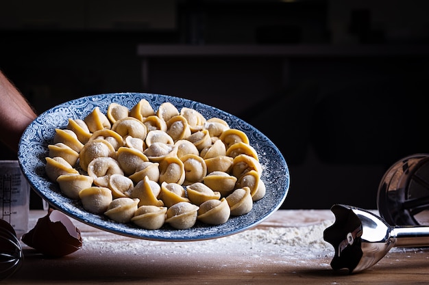 Domowe pierogi, pelmeni, ravioli. Surowe rosyjskie pelmeni.