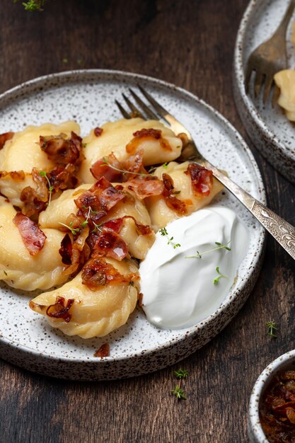 Domowe pierogi z ziemniakami, smażonym boczkiem i cebulą