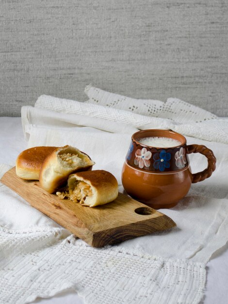 Domowe placki z kapustą i ceramiczny dzbanek mleka w stylu rustykalnym