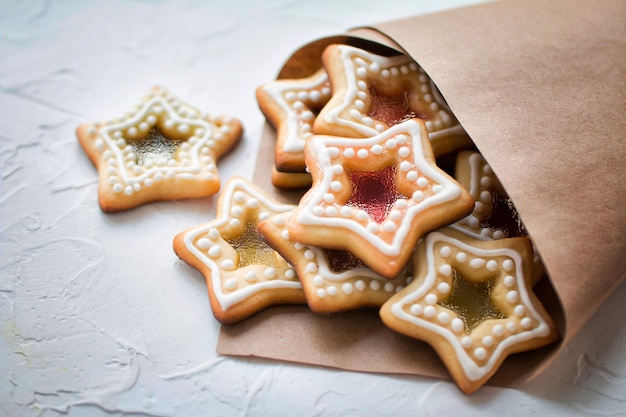 Domowe świąteczne ciasteczka karmelowe w kształcie gwiazdki w papierowym opakowaniu na białym tle