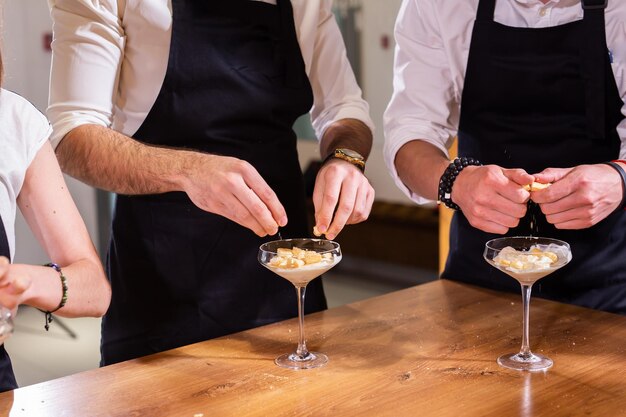 Domowe tiramisu w procesie gotowania szklanych słoików Tradycyjny nieupieczony włoski deser Ciasto kremowe z kawą i mascarpone