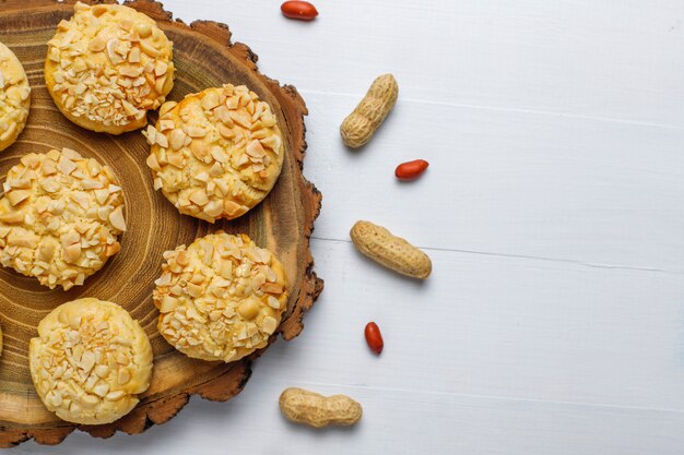 Domowej roboty crunchy ciastka z arachidami na biały drewnianym, odgórnym widoku ,.