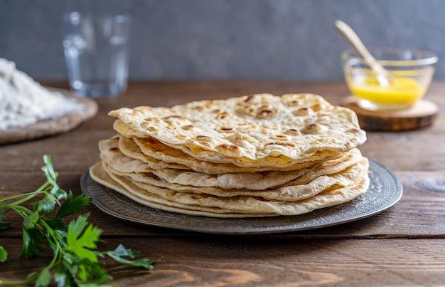 Domowy indyjski płaski chleb Chapati lub Roti z masłem z mąki ghee woda kolendra