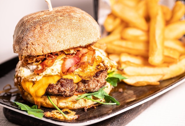 Domowy pikantny gorący cheeseburger z grillowanym serem wołowym i liściem sałaty między bułkami burgerowymi widok z boku koncepcja restauracji