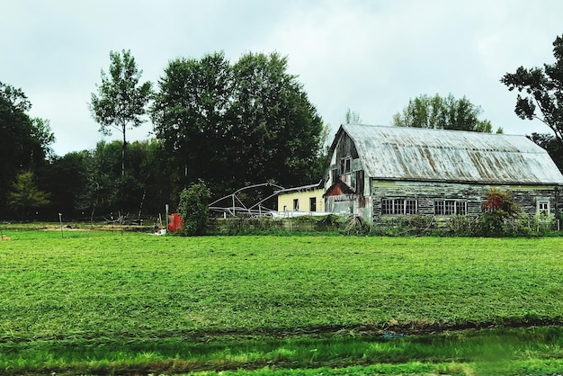 Zdjęcie domy na polu obok drzew na tle nieba