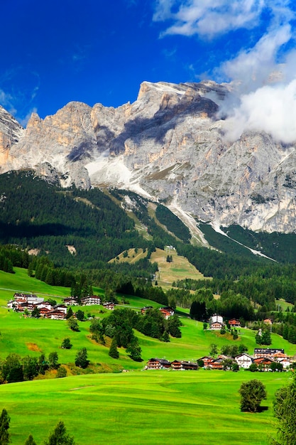 Domy na polu przeciwko dolomitom