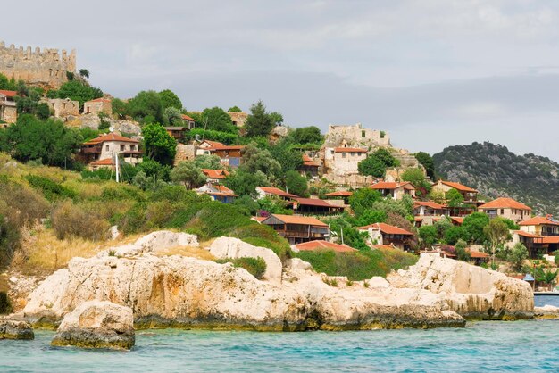 Domy z czerwonymi dachówkami na kamienistej plaży nad morzem