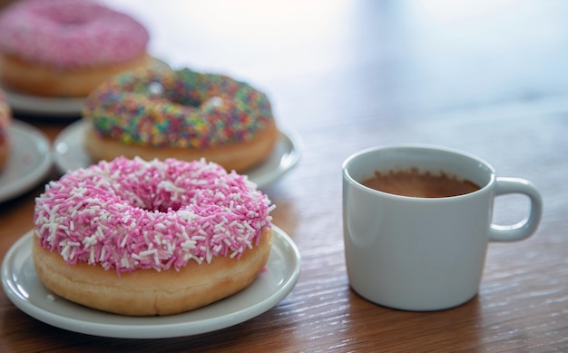 Donuts i filiżanka na drewnie Zamyka w górę widoku