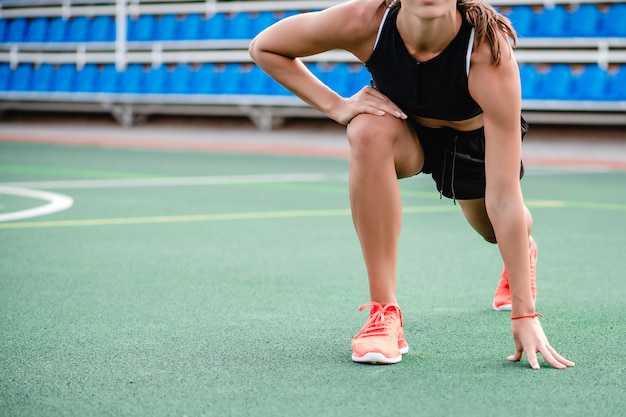 Dopasowanie sportowy kobieta robi trening fitness i poćwiczyć rano na stadionie