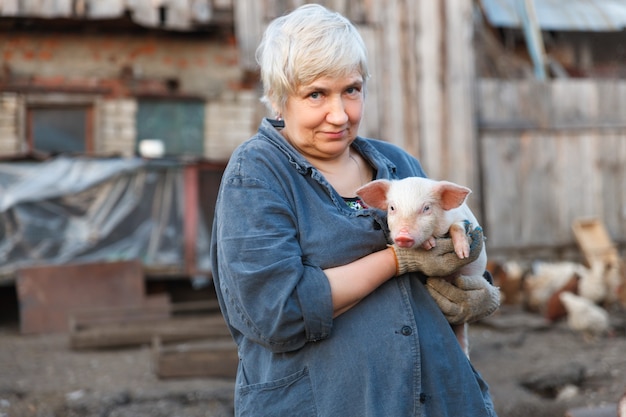 Dorosła kobieta trzyma małą świnię