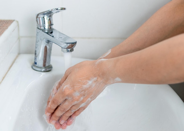 Dorośli myją ręce mydłem do rąk, aby zapobiec infekcji i wirusom