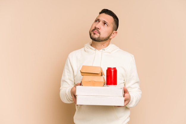 Dorosły mężczyzna z łaciny trzymający izolowane pakiety fast food