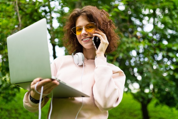 Dość Młoda Kaukaska Kobieta Pracuje W Parku I Dzwoni Na Telefon