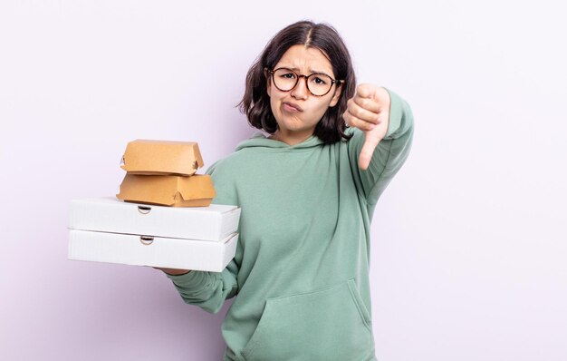 Dość młoda kobieta czuje krzyż, pokazując kciuk w dół. koncepcja fast food na wynos