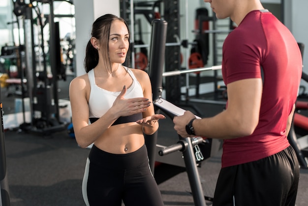 Dość Młoda Kobieta Rozmawia Z Trenerem Fitness