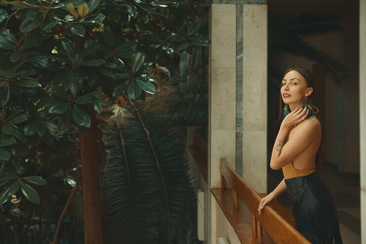 Dość młoda kobieta stojąca na balkonie hotelu, patrząc na enjoyi