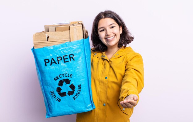 Dość młoda kobieta uśmiecha się radośnie z przyjaznym, oferującym i pokazującym koncepcję. koncepcja recyklingu papieru