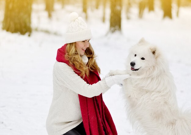 Dość młoda kobieta w Snowy Winter Forest Park Walking Walking z jej Dog White Samoyed Seasonal