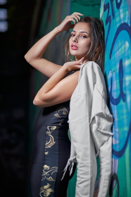 Dość młoda modelka z długimi prostymi włosami pozuje z obcisłymi spodniami i dżinsową kurtką na ulicach Madrytu w Hiszpanii