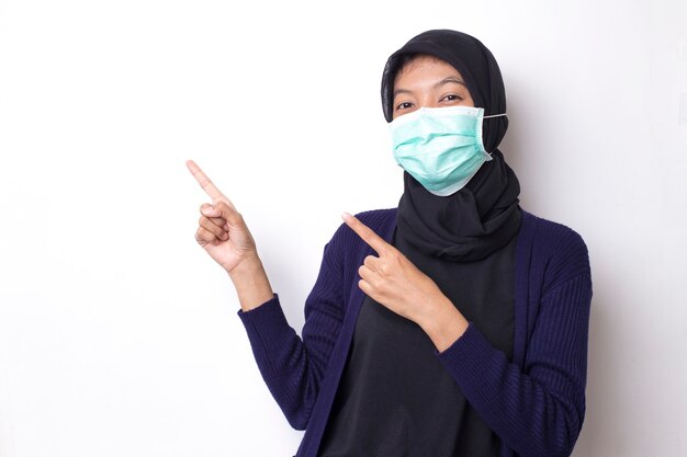 Dość muzułmańska młoda Azjatka z medyczną maską ochronną do ochrony infekcji przed koronawirusem na odosobnionej białej przestrzeni