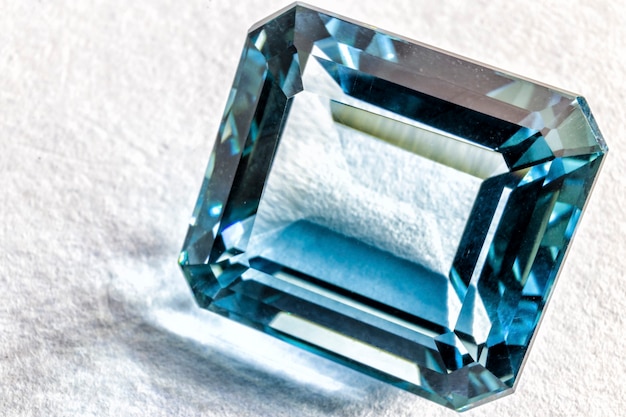 Dość niebieski kryształ kwarcu fasetowany na białej powierzchni