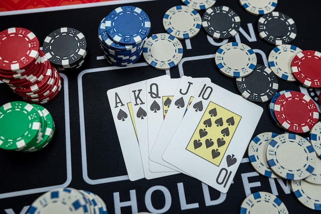 Doskonała kombinacja kart do wygrania w pokera z stosem żetonów na stole klubu kasynowego Nikt nie gra