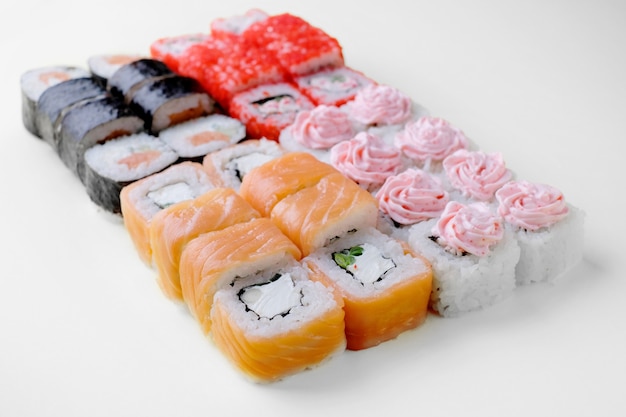 Dostawa do restauracji japońskiej żywności, zestaw sushi. Sushi Unagi, Tempura Rolls California z łososiem, krewetkami, tuńczykiem, kawiorem i serem na białym tle.