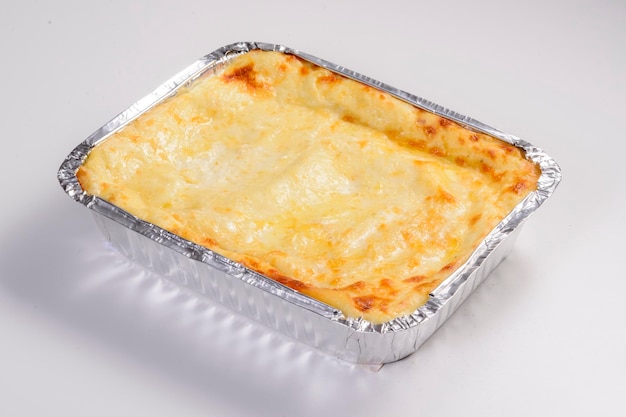 Dostawa lasagne Lasagne serowa w opakowaniu do dostawy na białym tle