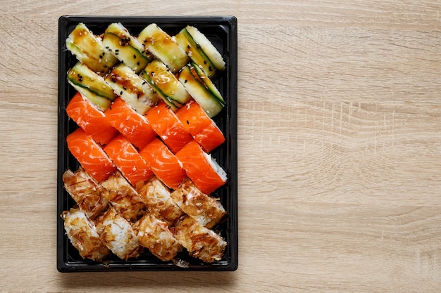 Dostawa - rolki sushi w plastikowym pudełku.