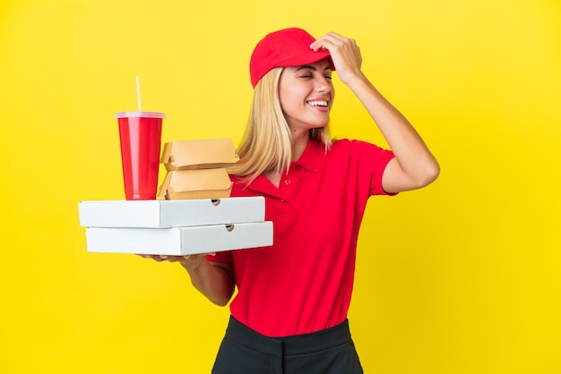 Zdjęcie dostawa urugwajska kobieta trzymająca fast food na żółtym tle uświadomiła sobie coś i zamierza znaleźć rozwiązanie