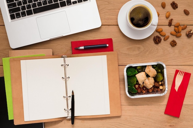 Dostawa zdrowej żywności. Pudełko na lunch z posiłkiem dietetycznym w miejscu pracy, płaskie ułożenie drewnianego pulpitu z foliowanym pojemnikiem, miejsce na kopię