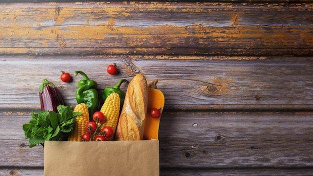 Dostawa zdrowej żywności tło Zdrowe wegańskie wegetariańskie jedzenie w papierowej torbie warzywa i owoce na drewnie kopia przestrzeń transparent Zakupy w supermarkecie spożywczym i koncepcja czystego wegańskiego jedzenia