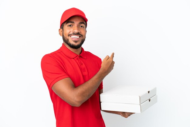 Dostawca pizzy, który podnosi pudełka po pizzy na białym tle, wskazując do tyłu