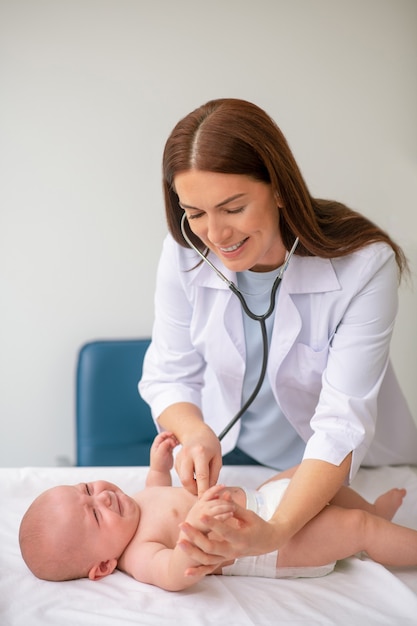 Doświadczona pediatra osłuchująca serce noworodka