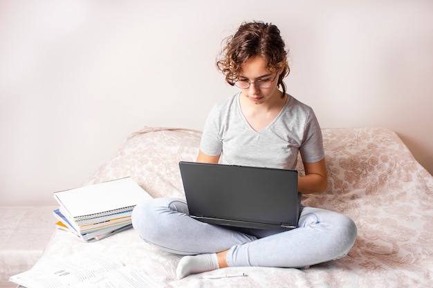 Dosyć Kędzierzawa Nastolatek Dziewczyna Studiuje Online Na łóżku Z Laptopem
