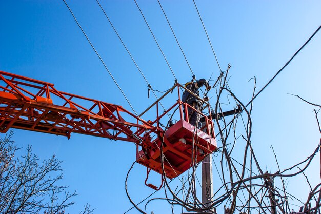 Drabina robocza działająca naprawia linię energetyczną na kablu elektrycznym z powietrznymi platformami roboczymi