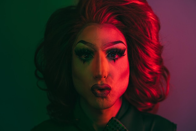 Drag Queen Patrząc Na Kamerę Z Neonowymi światłami W Studiu Lgbtq Concept