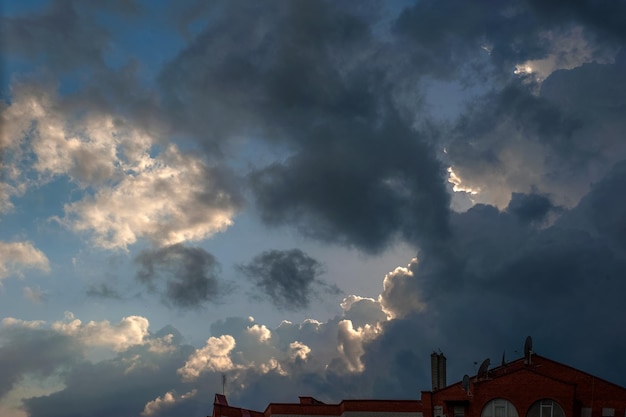 Dramatyczne ciemne pochmurne niebo nad dachami budynków miejskich