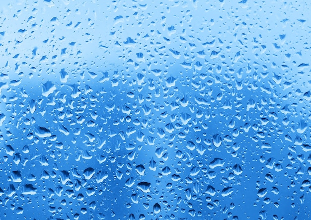 Dramatyczne krople wody na tle tekstury szkła okiennego