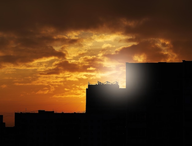 Zdjęcie dramatyczne rozbłyski słońca nad sylwetkami wieczornych budynków
